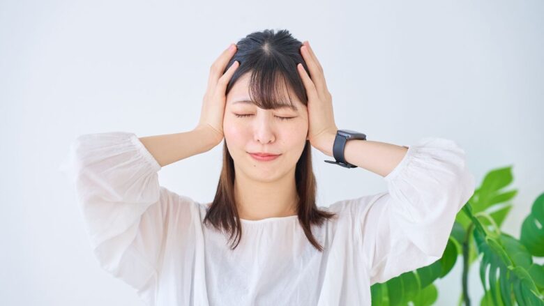 頭を抱えて悩む女性のイメージ