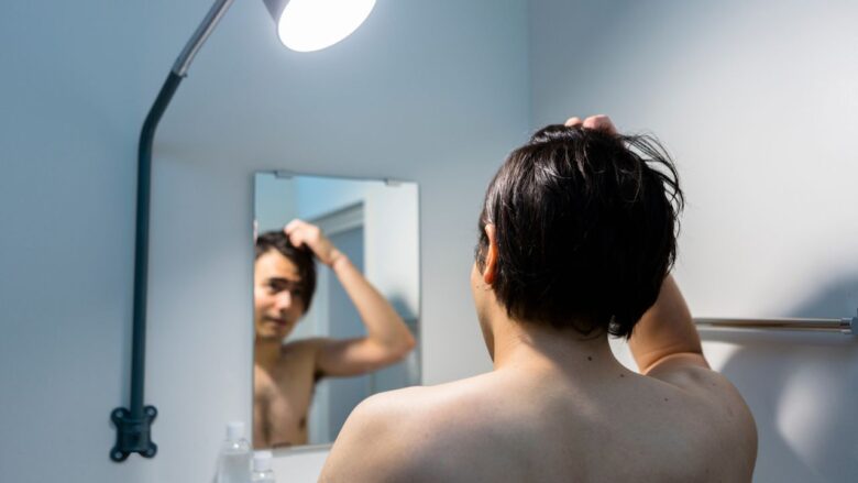 自分の姿を見る男性