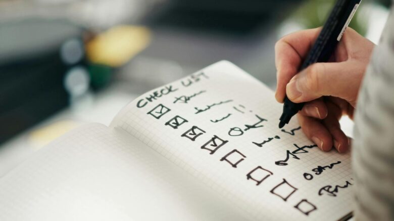 チェックリストにチェックを入れている女性のイメージ