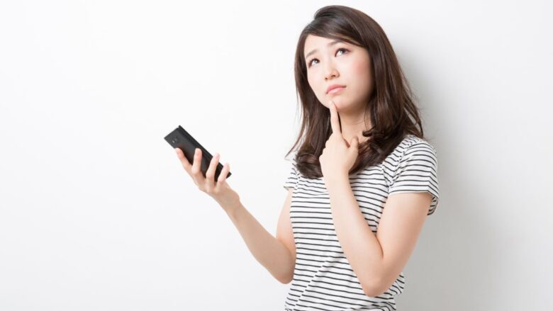 アプリ版とWEB版どっちで登録するか悩む女性のイメージ