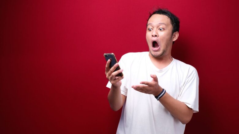 金銭トラブルを示すメッセージを見て驚く男性